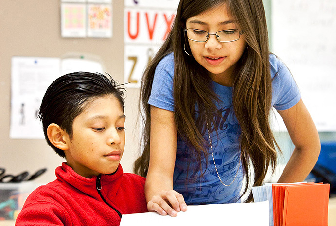 Två barn i förskoleklass som tittar på ett papper.